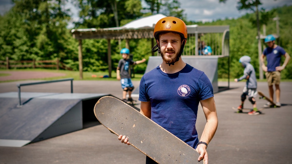 male skateboard counselor working at summer camp