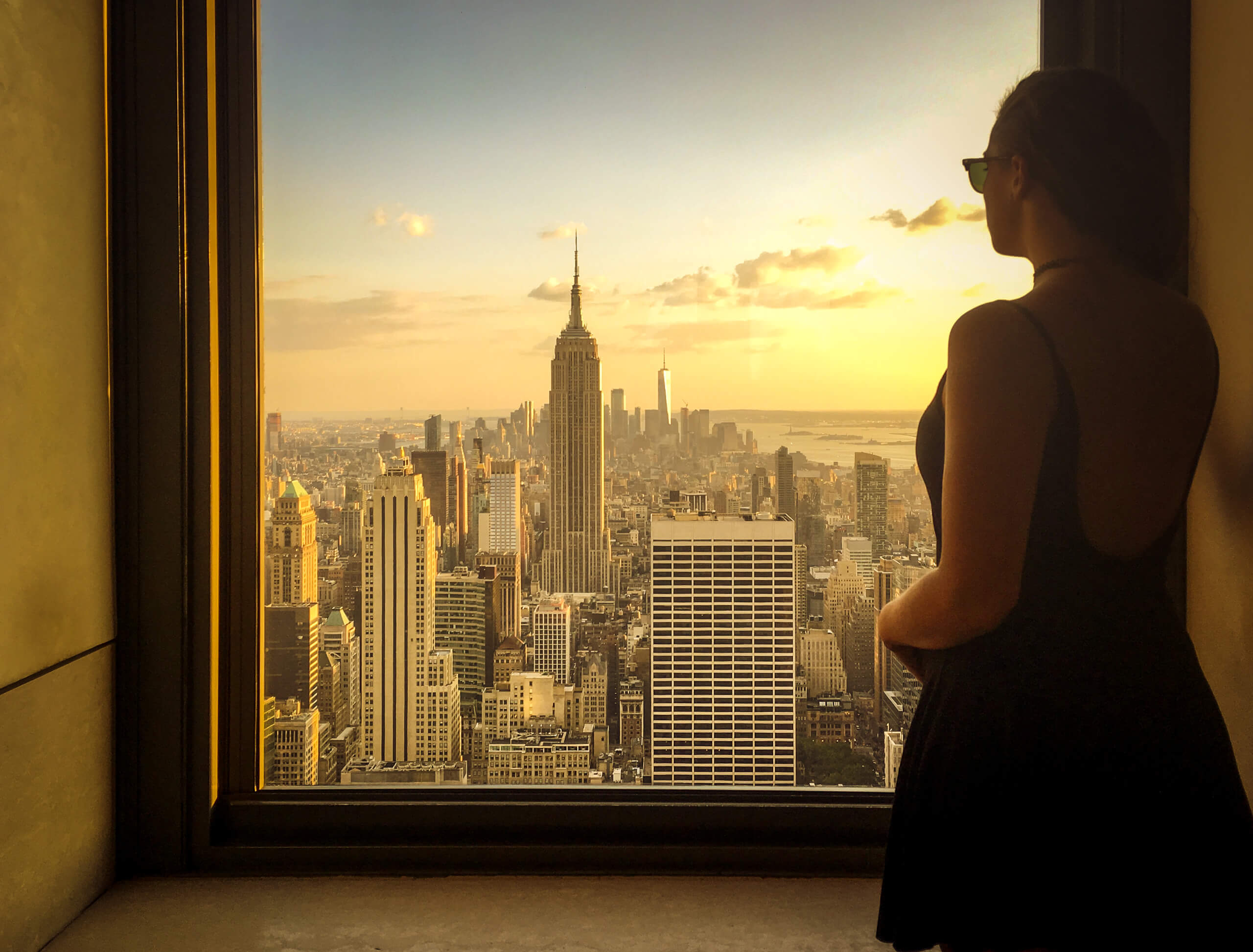 A woman looking out at the New York City skyline.